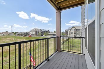 The view from the balcony of an apartment building with a flag on the balcony railing